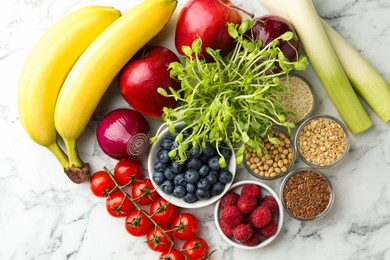 Photo of Different fresh products on white marble table, flat lay. Source of prebiotics