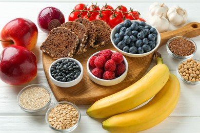 Photo of Different fresh products on white wooden table. Source of prebiotics