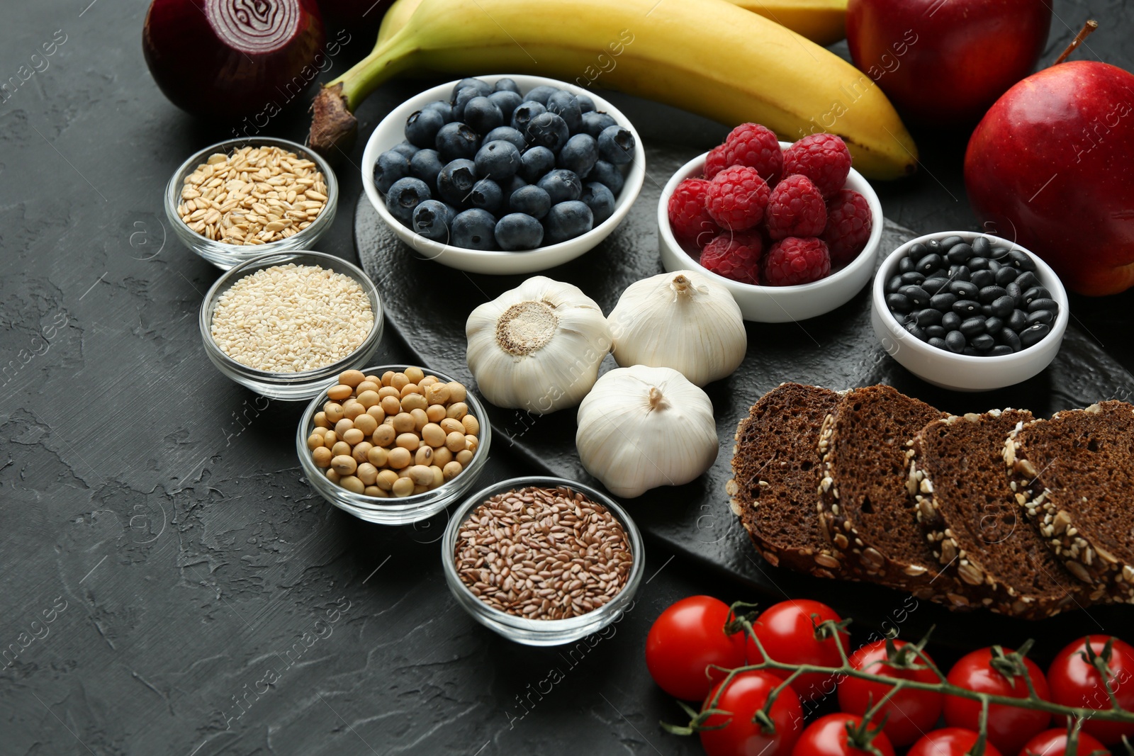 Photo of Different fresh products on black table. Source of prebiotics