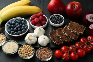 Photo of Different fresh products on black table. Source of prebiotics