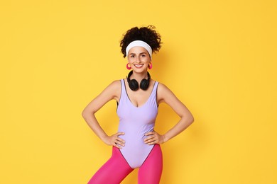 Happy woman with headphones on orange background