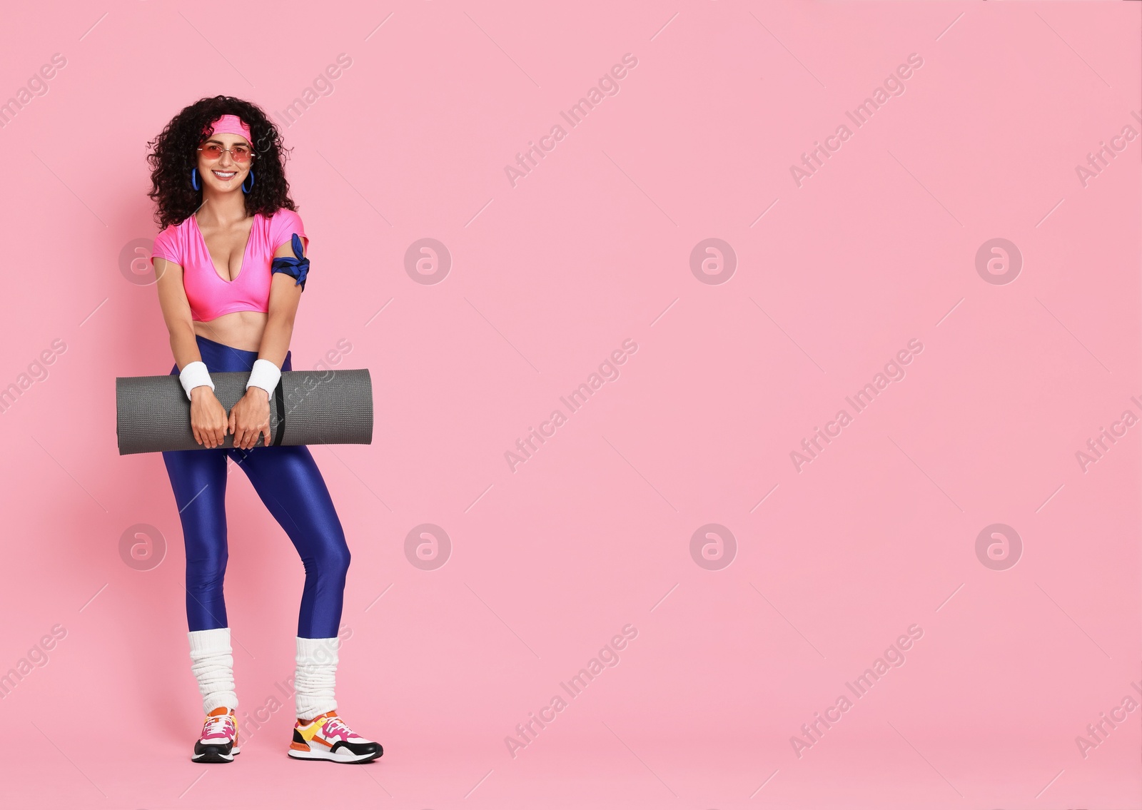 Photo of Aerobics. Happy woman with fitness mat on pink background, space for text