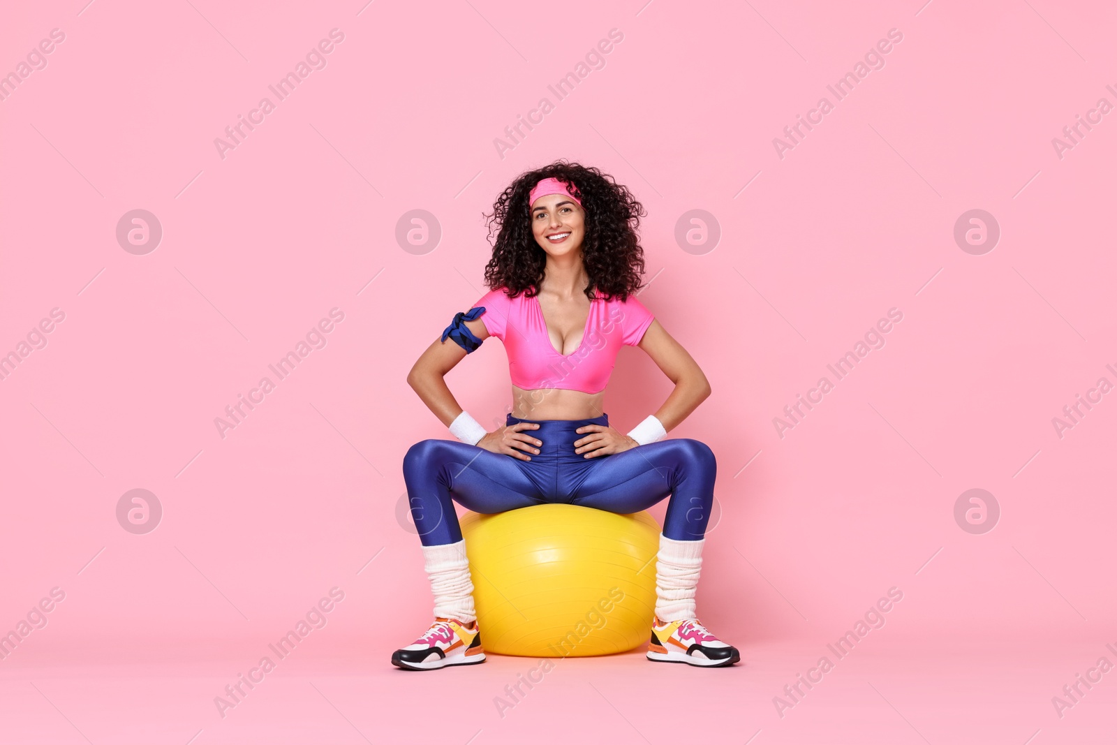 Photo of Aerobics. Happy woman with fitness ball on pink background