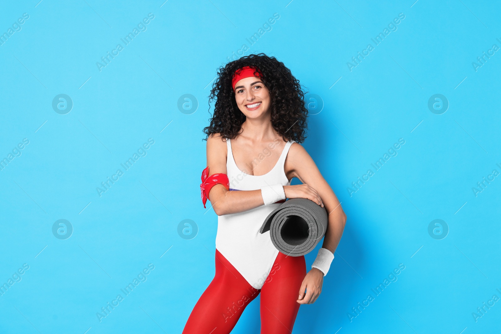 Photo of Aerobics. Happy woman with fitness mat on light blue background