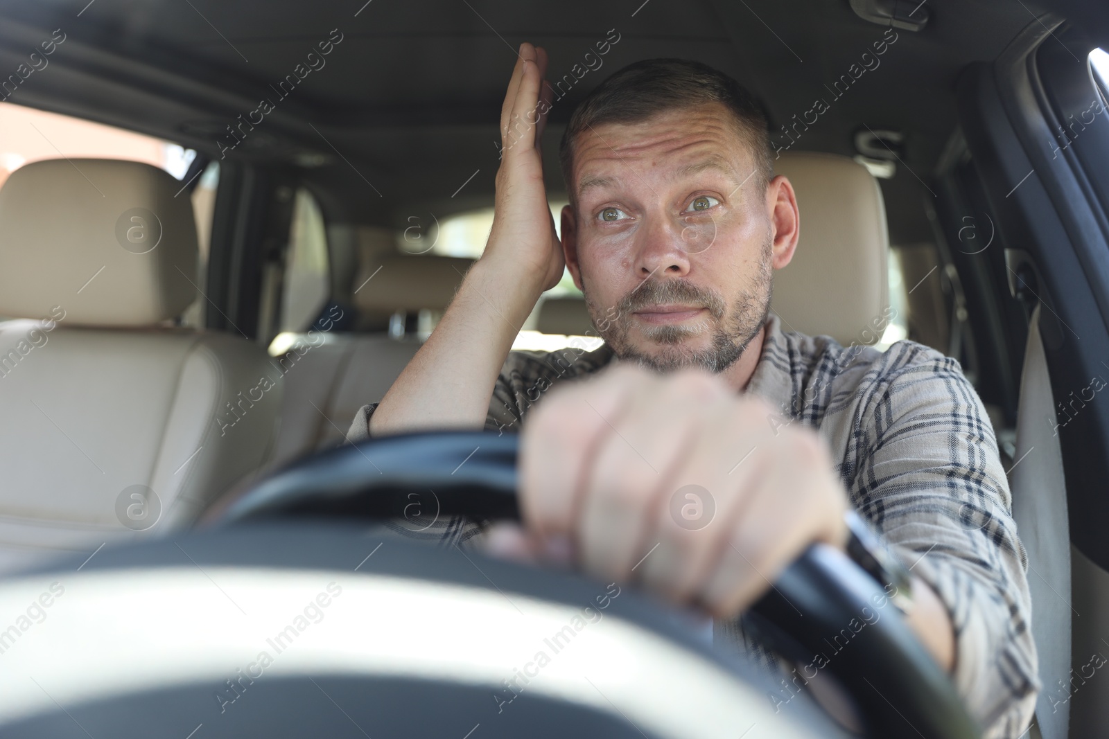 Photo of Man holding steering wheel while driving car, view through windshield