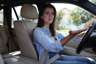 Emotional woman holding steering wheel while driving car