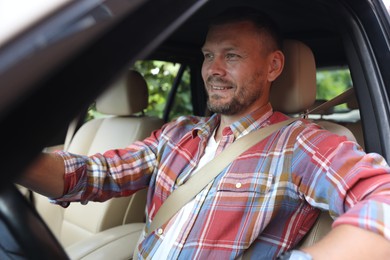 Man holding steering wheel while driving car