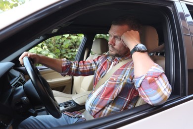 Man holding steering wheel while driving car, view from outside