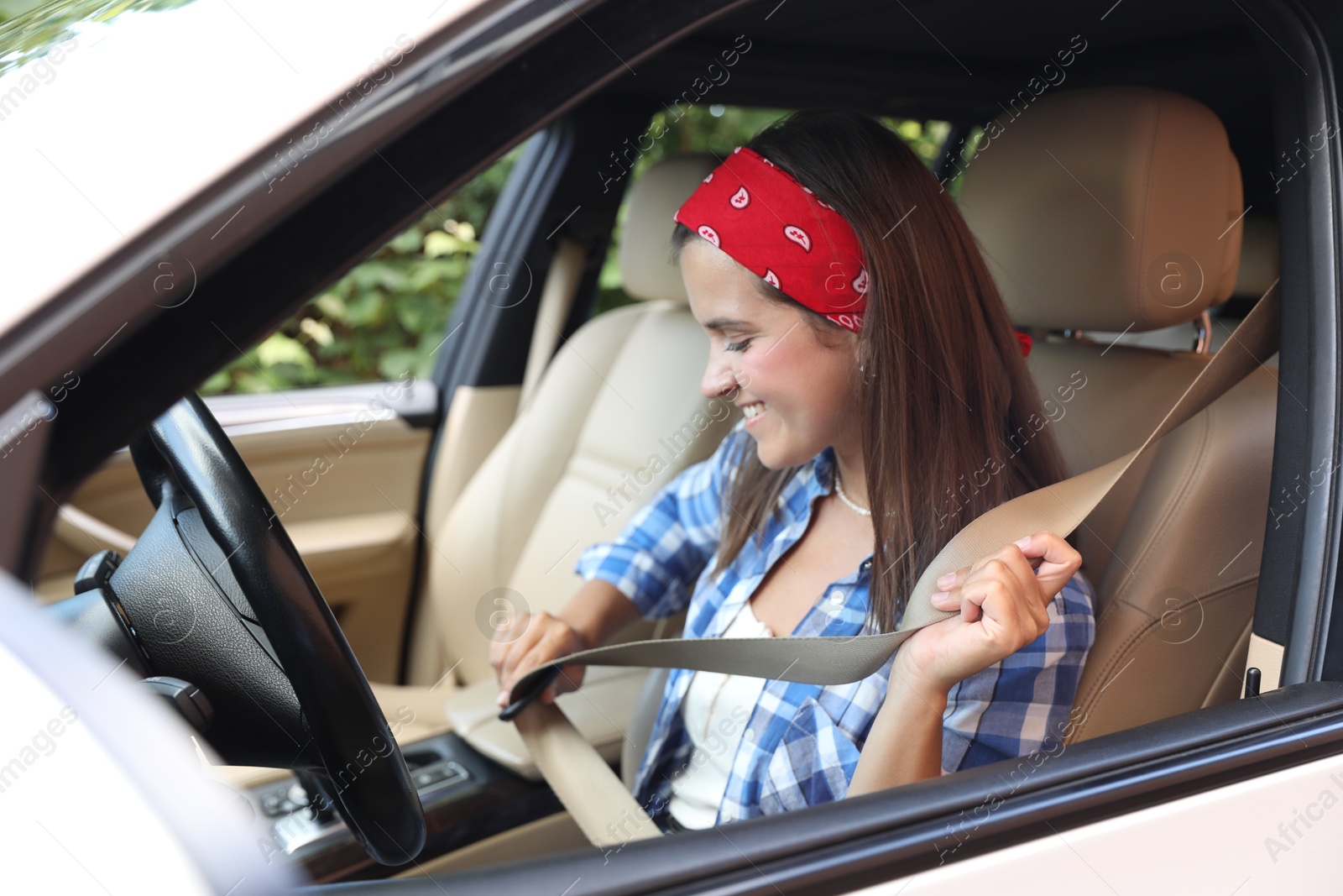 Photo of Smiling woman fastening safety seat inside car