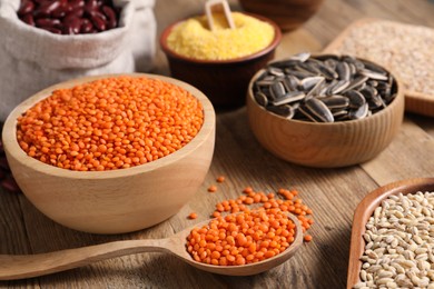 Different types of cereals, seeds and legumes on wooden table