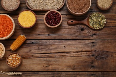 Photo of Different types of cereals, seeds and legumes on wooden table, flat lay. Space for text