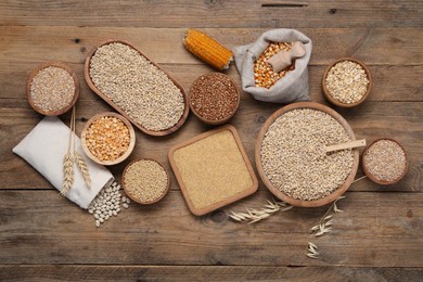 Photo of Different types of cereals and legumes on wooden table, flat lay