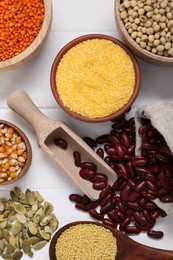 Photo of Different types of cereals, seeds and legumes on white wooden table, flat lay