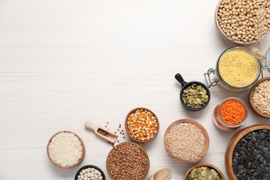 Photo of Different types of cereals, seeds and legumes on white wooden table, flat lay. Space for text