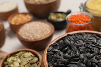 Photo of Different types of seeds, cereals and legumes on white table, closeup