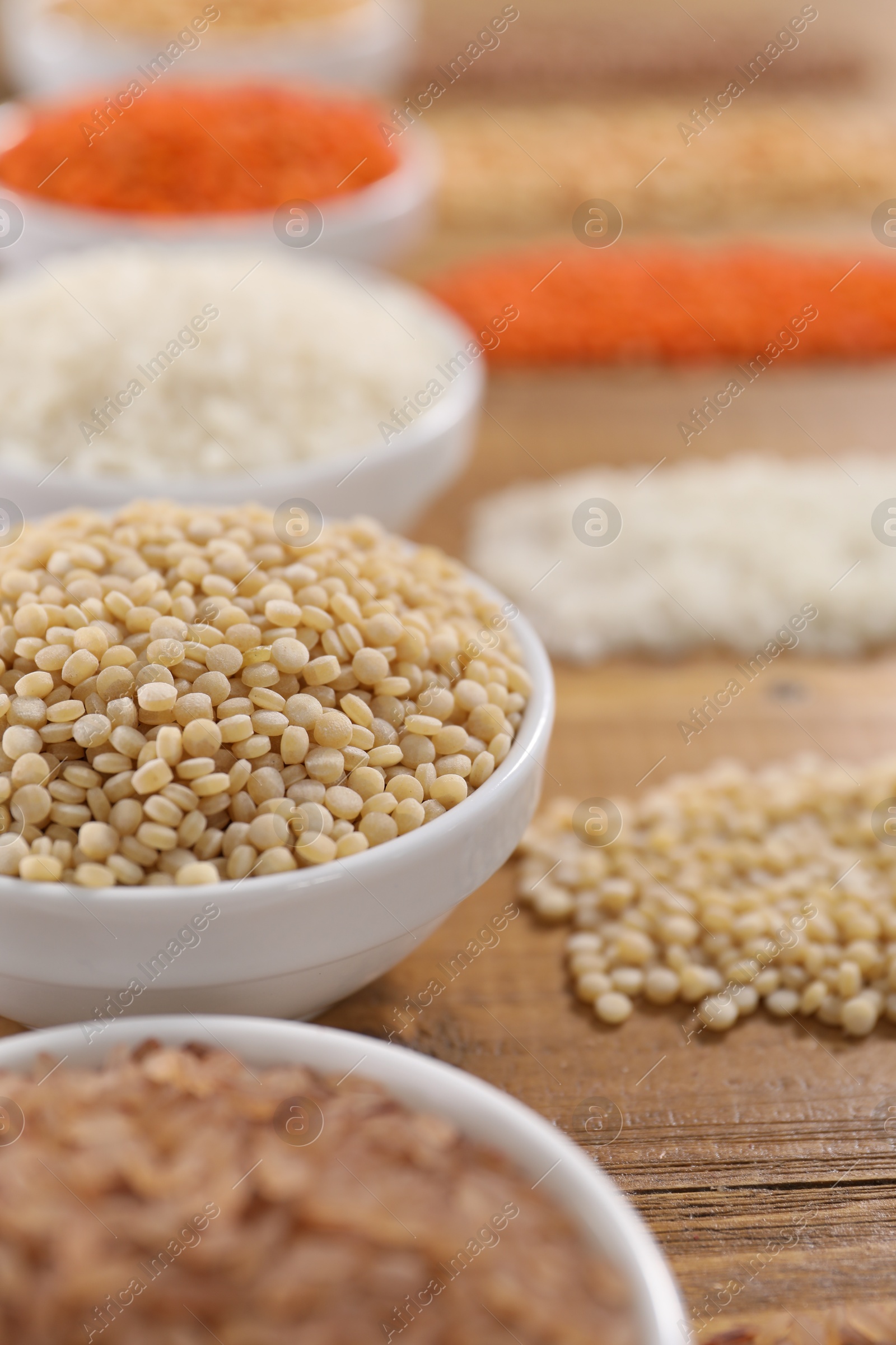 Photo of Different types of cereals and legumes on wooden table, closeup