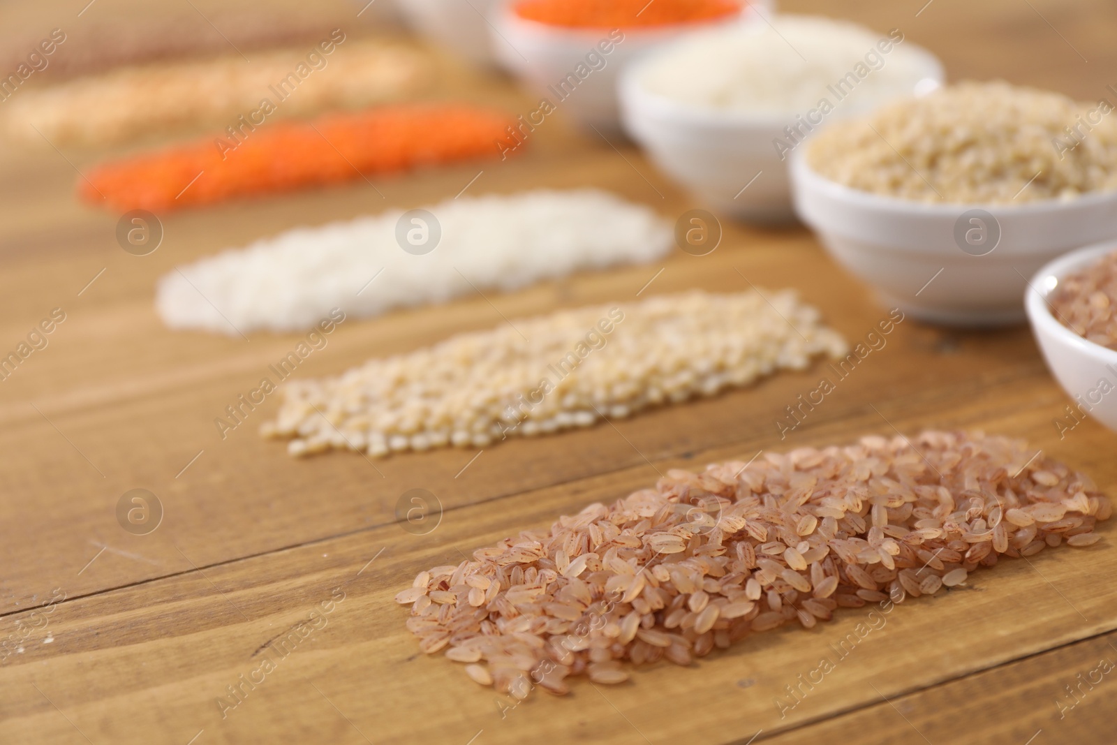 Photo of Different types of cereals and legumes on wooden table, closeup