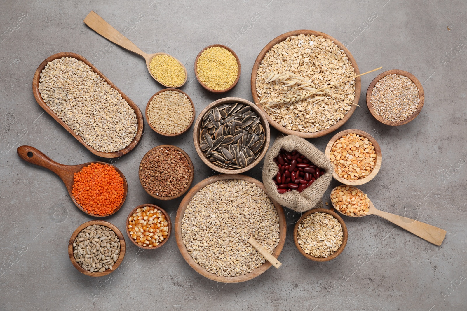 Photo of Different types of cereals, seeds and legumes on grey table, flat lay