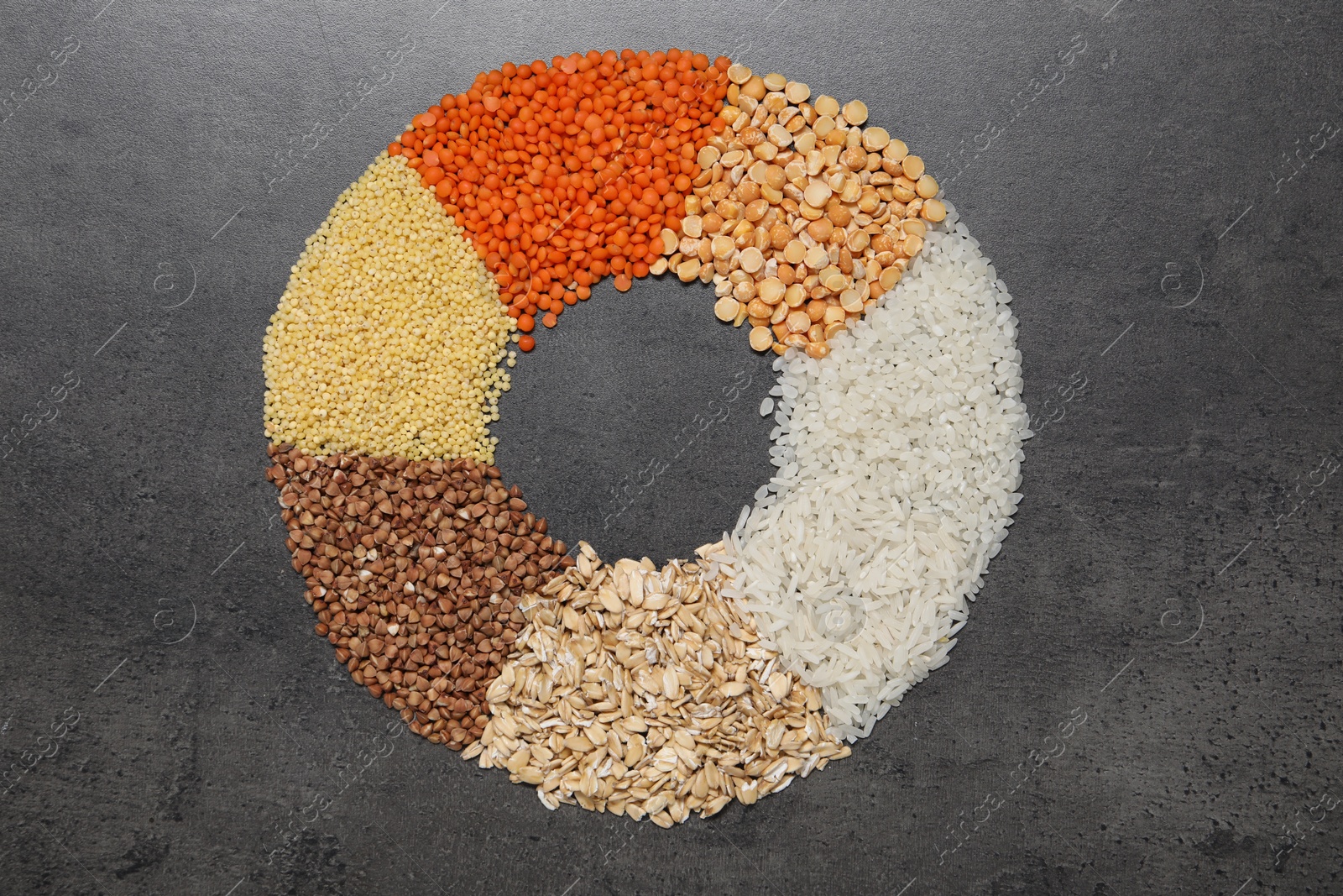 Photo of Different types of cereals and legumes on grey table, top view