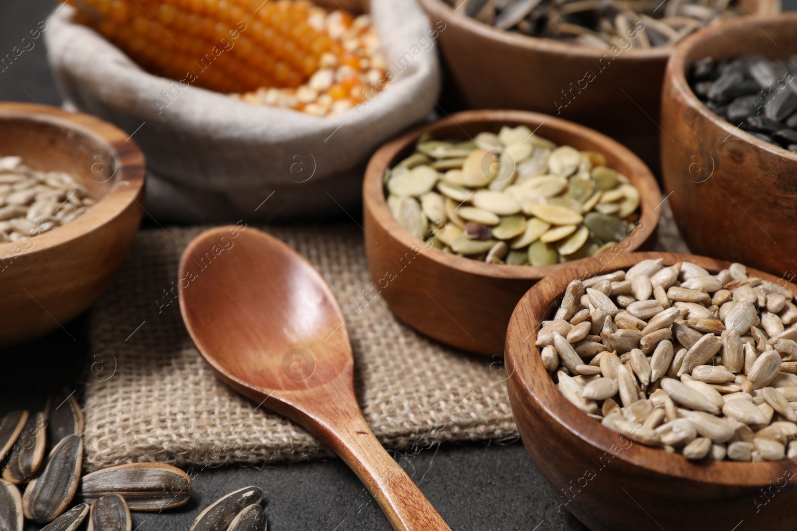 Photo of Different types of seeds and legumes on grey table