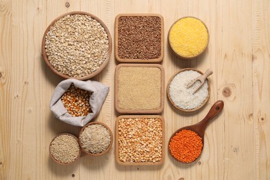 Photo of Different types of cereals and legumes on wooden table, flat lay