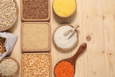 Photo of Different types of cereals and legumes on wooden table, flat lay