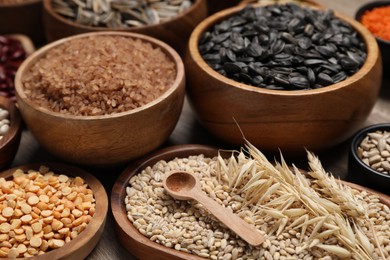 Photo of Different types of cereals and seeds on table, closeup