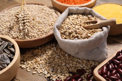 Photo of Different types of cereals and legumes on wooden table, closeup