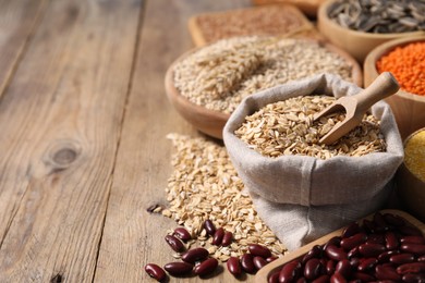 Photo of Different types of cereals and legumes on wooden table, closeup. Space for text