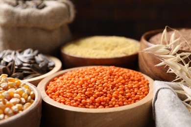 Different types of cereals, seeds and legumes on table, closeup