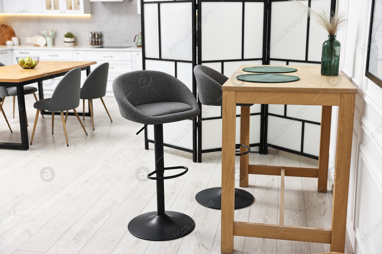 Photo of Bar stools and table near folding screen indoors