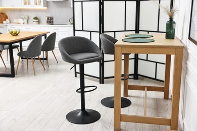 Photo of Bar stools and table near folding screen indoors