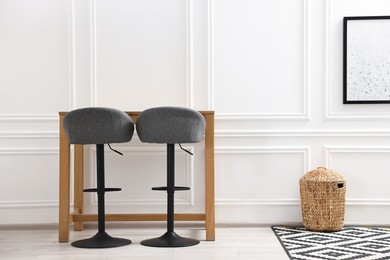 Photo of Bar stools near table in stylish room