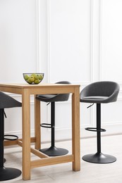 Photo of Bar stools and table near white wall