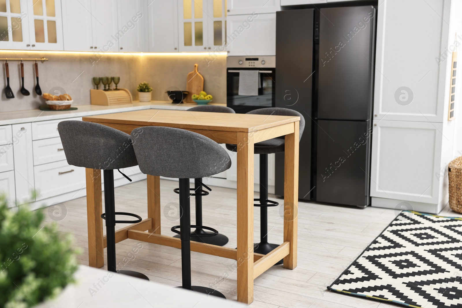 Photo of Bar stools near table in stylish kitchen