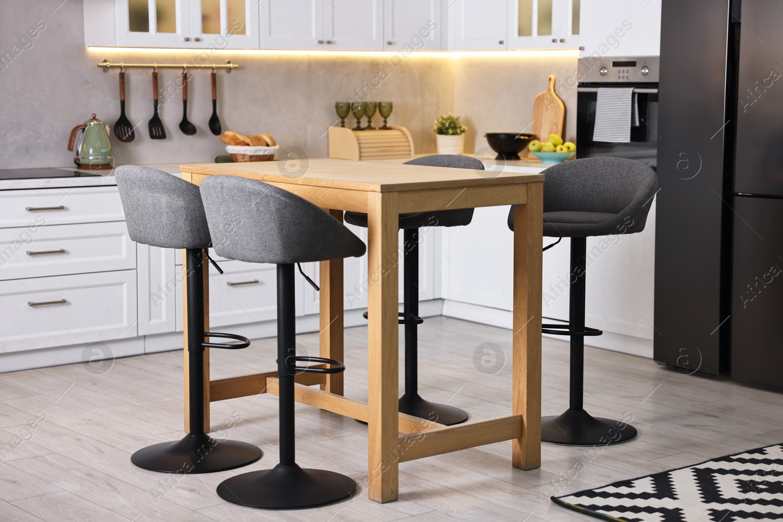 Photo of Bar stools near table in stylish kitchen