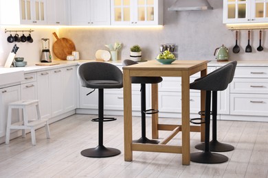 Photo of Bar stools near table in stylish kitchen