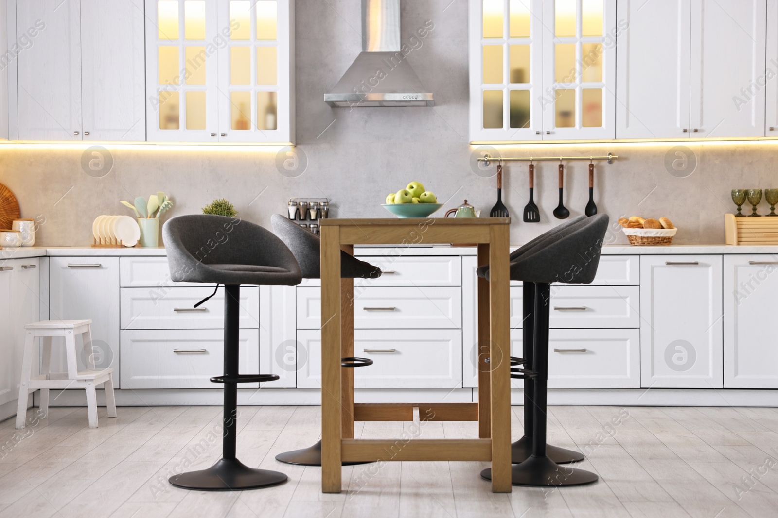 Photo of Bar stools near table in stylish kitchen