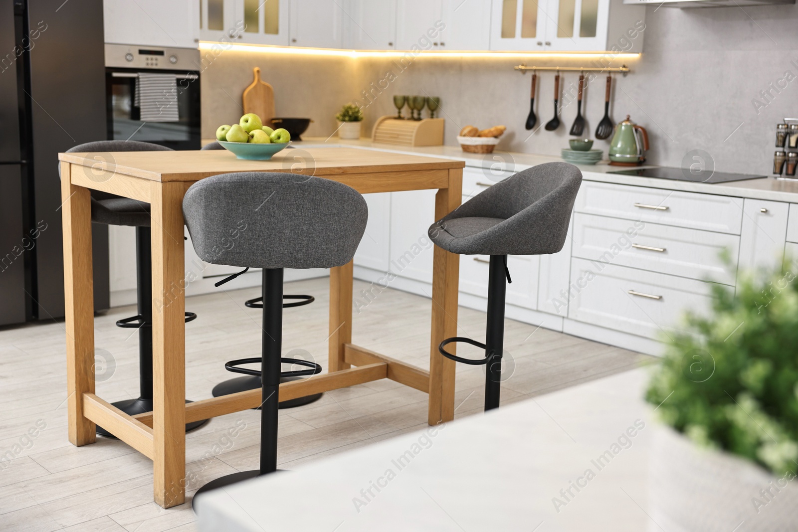 Photo of Bar stools near table in stylish kitchen