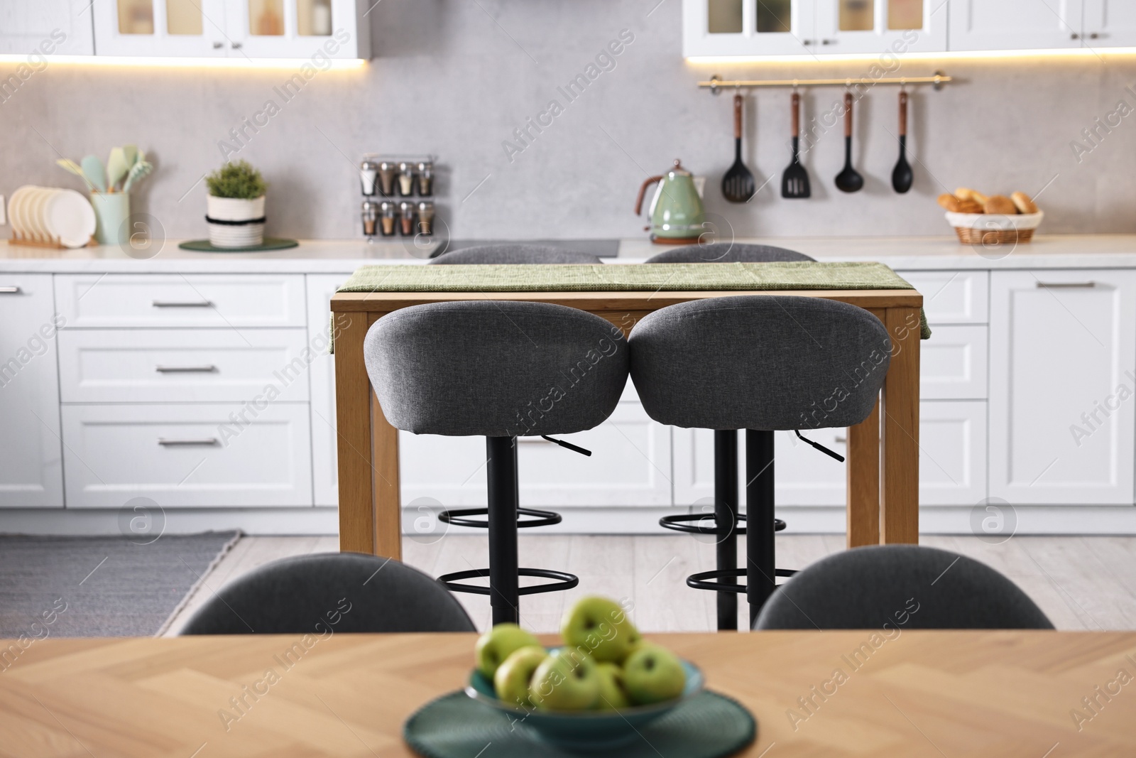 Photo of Bar stools near table in stylish kitchen