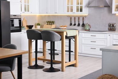 Photo of Bar stools near table in stylish kitchen