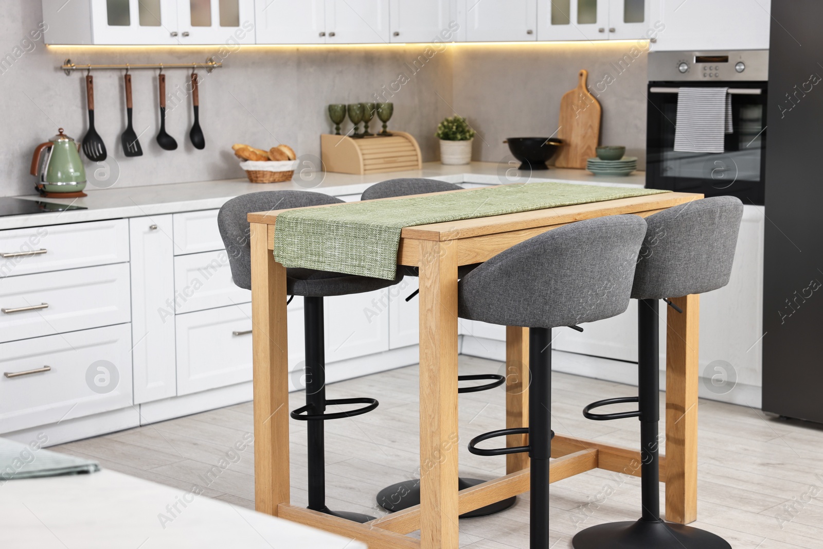 Photo of Bar stools near table in stylish kitchen