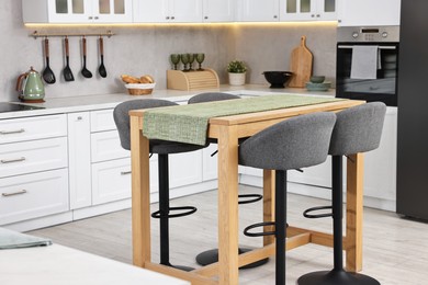 Photo of Bar stools near table in stylish kitchen