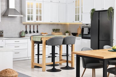 Photo of Bar stools near table in stylish kitchen