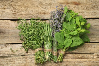 Different aromatic herbs on wooden table, top view