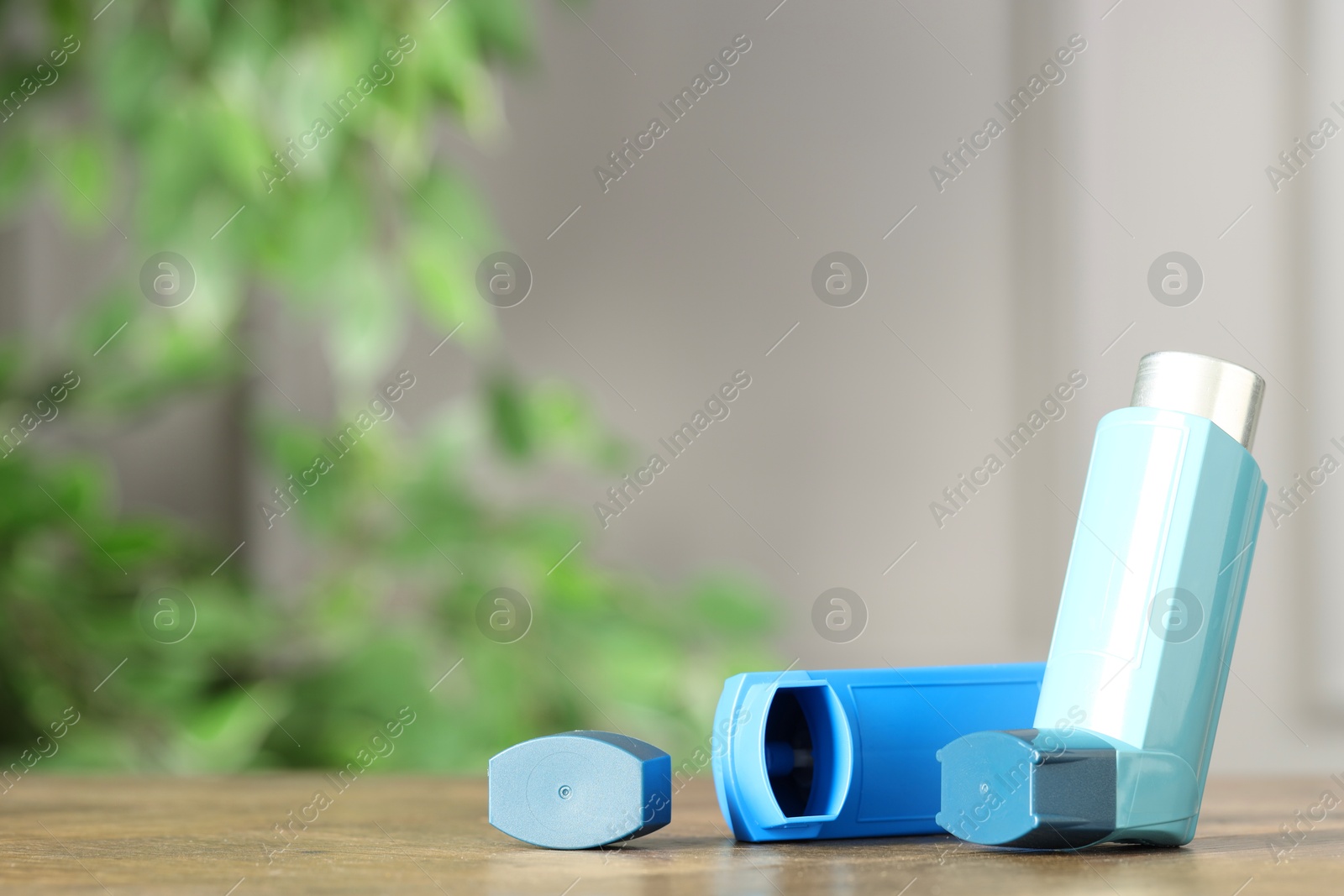 Photo of Inhalers on wooden table indoors, closeup with space for text. Asthma treatment