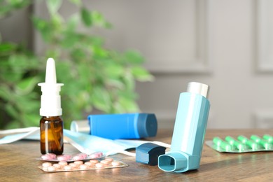 Photo of Different asthma medications on wooden table indoors, closeup