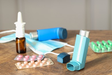 Photo of Different asthma medications on wooden table indoors, closeup