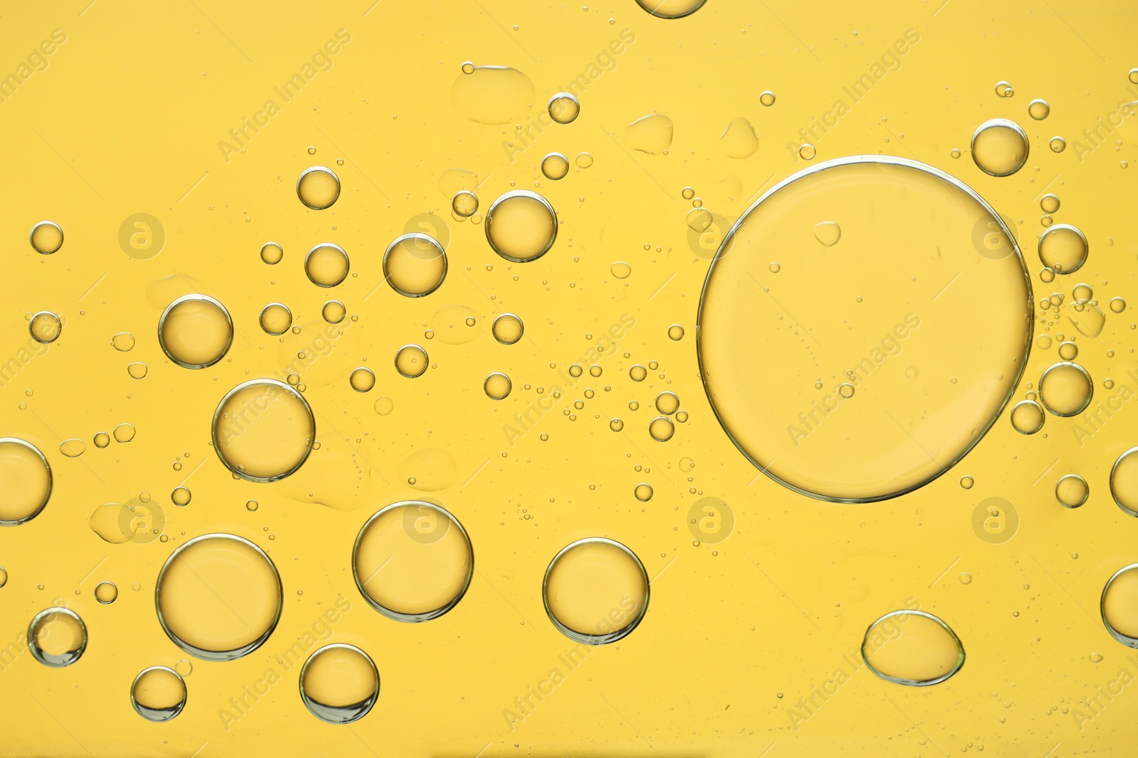 Photo of Sample of cosmetic oil on golden background, macro view