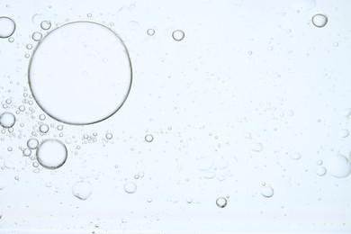 Photo of Sample of cosmetic oil on white background, macro view